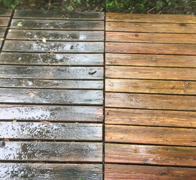 A wooden deck with water and moss on it.