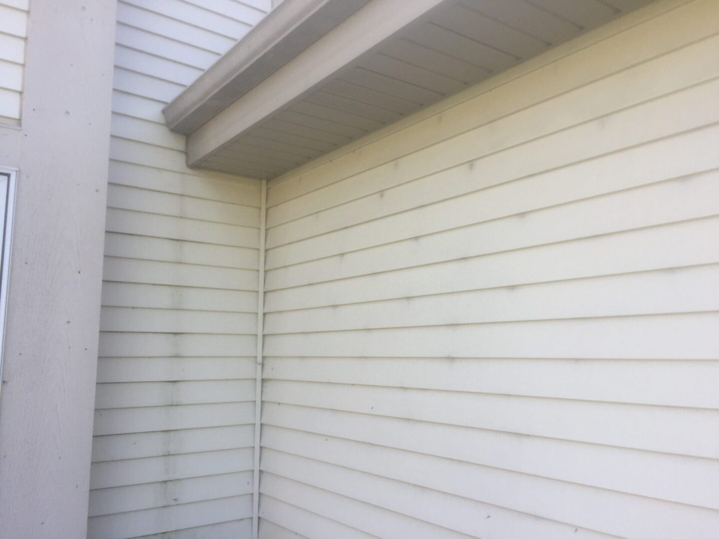 A white wall with a window and a roof